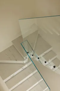 Modern staircase with marble steps and a glass railing