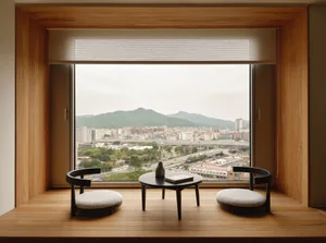A cozy living room with a modern window overlooking a cityscape.