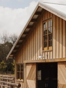 A modern barn-style building with wooden siding and a corrugated metal roof.