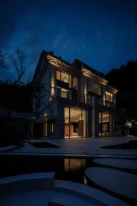 A modern residential building with concrete exterior at nighttime, featuring illuminated windows and a courtyard with water f