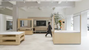 A minimalist retail storefront featuring a modern design with wooden elements and a large display window.