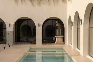 Minimalist residential exterior with concrete walls and a serene pool area.