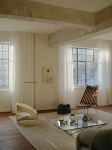 A minimalist living room featuring wood, concrete, and glass materials.