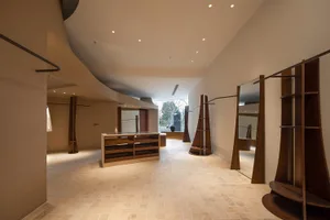Modern retail shop featuring wooden fixtures, glass display cases, and stone flooring.