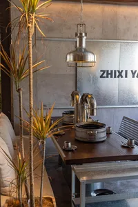 A modern, industrial-style restaurant interior featuring metal tables and chairs, wood accents, and minimalist decor.
