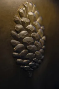 A close-up view of a metallic pine cone decorative element.