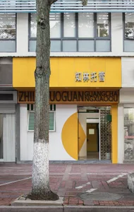A modern building with a yellow facade and black Chinese characters on it.