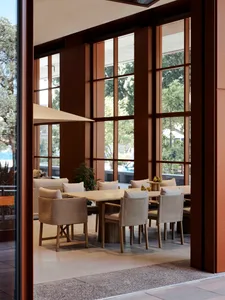 Modern restaurant interior with a long wooden dining table, stone countertops, and contemporary design elements.