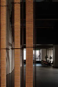 The interior of a modern restaurant featuring glass and metal geometric columns.