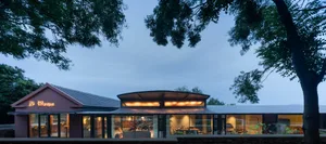 Modern cabin-style house with wooden walls, glass windows, and metal accents.