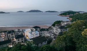 A residential beachfront property with houses and trees on the shore