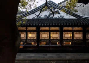 Traditional Chinese pavilion with wooden frame and tiled roof at night.