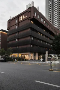 A modern hotel building with a black concrete exterior.