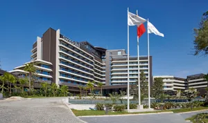 Hotel exterior with modern architectural design featuring concrete, glass, and steel materials.
