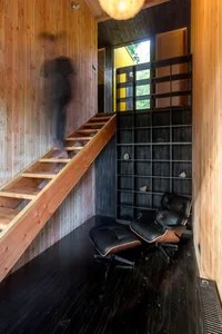 A modern living space featuring a wooden staircase with black accents.