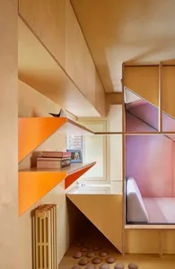 A minimalist residential living room featuring a stylish geometric shelving unit, a cozy seating area, and a window with a vi