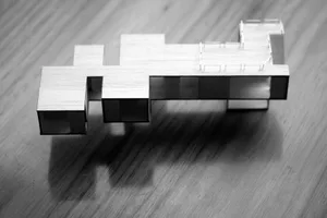 A wooden model of a modern building with minimalist design.
