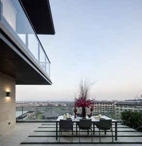 A modern dining room with transparent glass panels and a view of the cityscape.