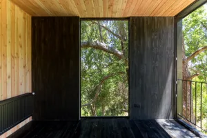 A modern interior design featuring a wooden balcony with a view of greenery, emphasizing contemporary and minimalist aestheti