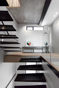 Black metal staircase with concrete floor and minimalist decor.