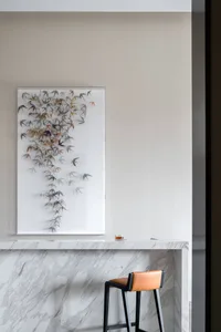 A modern interior design featuring marble materials, with a bird art sculpture and a bar counter.