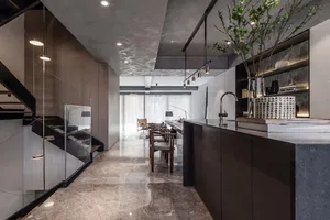 Modern kitchen with marble countertops and floor, featuring minimalist design elements and sleek, black accents.