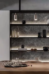 A modern kitchen with marble countertops and shelves.