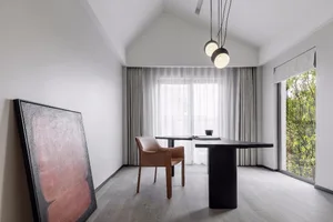 A minimalist study room featuring a black table, brown leather chair, large abstract painting, and white curtains