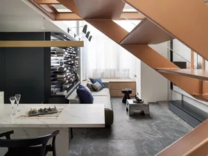 A modern living room featuring concrete and brass elements.