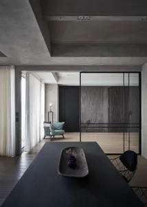 A modern living room with concrete curtains, wooden flooring, and a minimalist design.