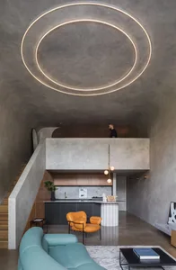 Modern living room and kitchen with open-plan design, featuring concrete texture walls and floors.