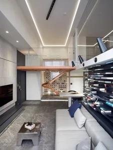 Modern living room with a metal coffee table, concrete floor, and wooden accents.