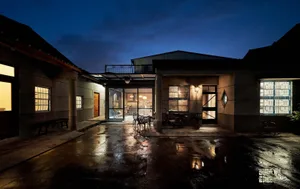A modern residential property with a concrete yard at dusk.