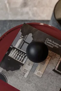 A photorealistic depiction of an interior design featuring a black sphere and a book with architectural imagery.