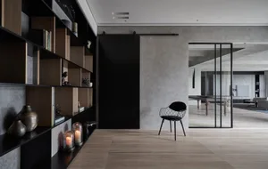 A minimalist residential interior featuring concrete, wood, and metal materials.