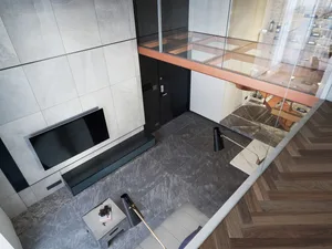 Modern living room with concrete walls, floor-to-ceiling windows, and minimalistic furniture.