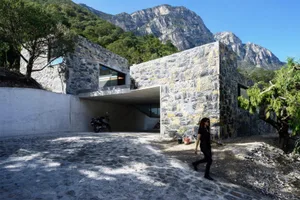 A modern residential home with a stone exterior and concrete entrance.