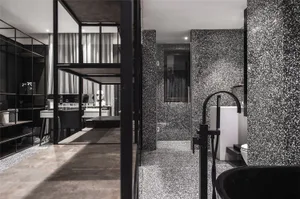 A modern bathroom featuring black and white terrazzo tiles.