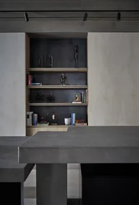 A modern home office with minimalist design, concrete table, wooden shelves, and a combination of concrete and wood materials