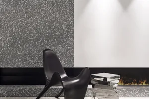 A modern living room with a unique black chair and metallic coffee table.