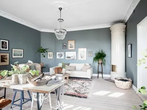A modern Scandinavian living room with a white couch, gallery wall, and white fireplace.
