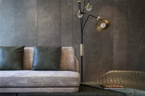 Minimalist living room with modern furniture in muted tones, featuring a comfortable sofa with plush cushions and a metallic 
