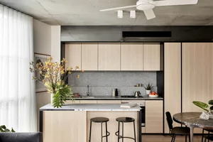 A minimalist kitchen with wooden cabinets, granite countertops, and a central island.