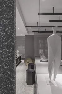 Modern interior featuring white and textured gray floor tiles with black accents and geometric shapes.