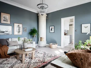 A cozy Scandinavian living room with a white sofa, wooden table, and plants.