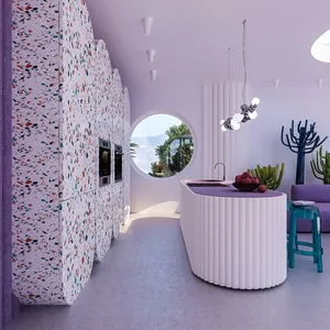 Modern minimalist kitchen with colorful terrazzo flooring and circular window overlooking a green landscape.