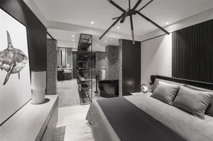 Contemporary bedroom with black, grey, and white palette, featuring a king-sized bed with a black headboard and grey linens, 