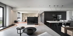 A modern living room with sleek, minimalist furniture and concrete flooring.