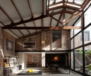 Industrial-style living space featuring exposed brick walls and large windows