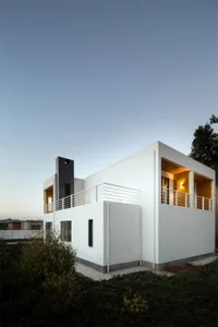 A modern house with a white, concrete exterior.